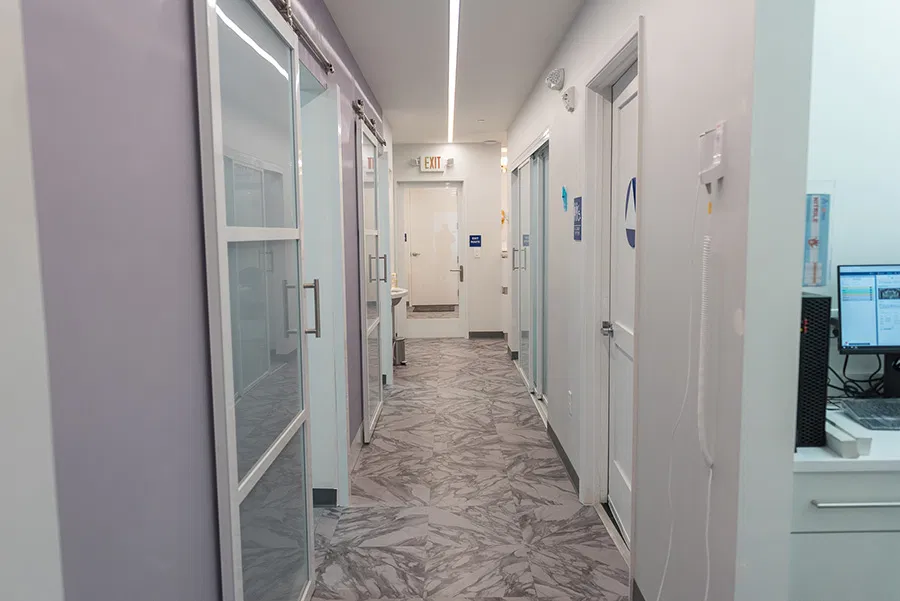 Bright, clean hallway in facial spa with multiple treatment room doors visible